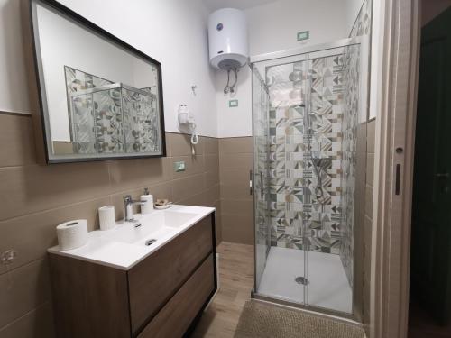 a bathroom with a shower and a white sink at Abaton - Casa vacanza in Metaponto