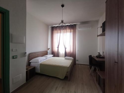 a small bedroom with a bed and a window at Abaton - Casa vacanza in Metaponto