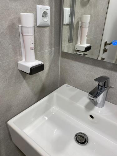 a bathroom with a white sink and a mirror at Arletti Luxury Apartment in Ruse