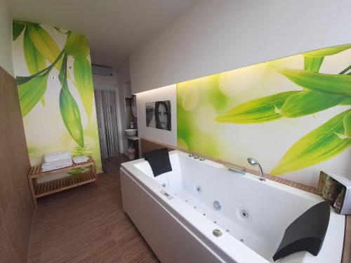 ein Badezimmer mit einer weißen Badewanne und einer grünen Wand in der Unterkunft ARCO VESUVIANO in Madonna dellʼArco
