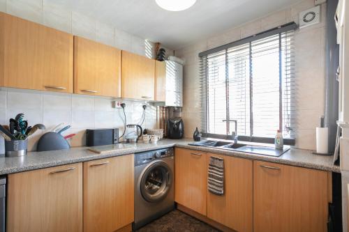 een keuken met een spoelbak en een wasmachine bij BED AT BOWBRIDGE Double Room in Newark upon Trent