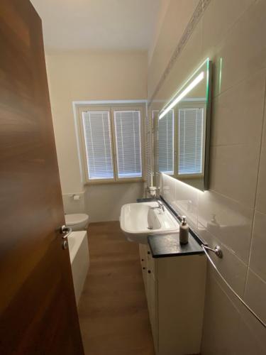 y baño con lavabo, aseo y espejo. en Aquamarine Apartment, en Castellammare di Stabia