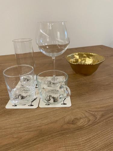 a wooden table with two glasses and a wine glass at Arletti Luxury Apartment in Ruse