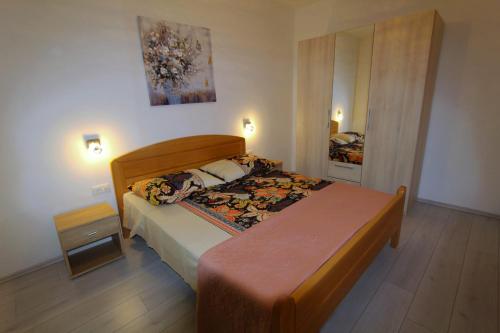 a bedroom with a bed with a wooden headboard at Villa Lujko in Prapatnica