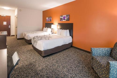 a hotel room with two beds and a chair at Sleep Inn & Suites Hurricane Zion Park Area in Hurricane