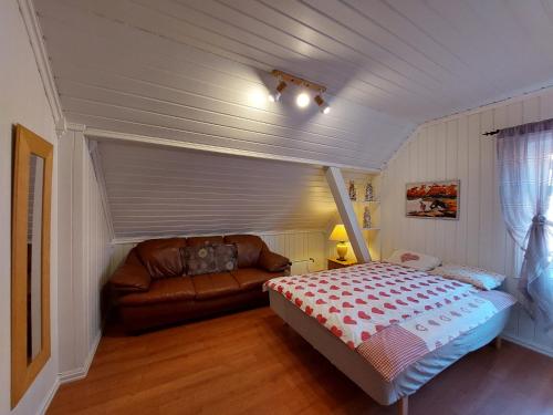 a small bedroom with a bed and a couch at Egil's Vacation House in Lillehammer