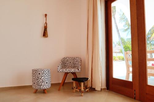 a room with a chair and a speaker next to a door at Kijani Beach Villas in Bwejuu