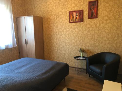 sypialnia z łóżkiem i krzesłem w obiekcie Kelemen Nyaraló Balatonmáriafürdő w mieście Balatonmáriafürdő