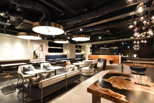 eine Lobby mit Sofas und Tischen und einer Bar in der Unterkunft Hotel Cordia Osaka Hommachi in Osaka