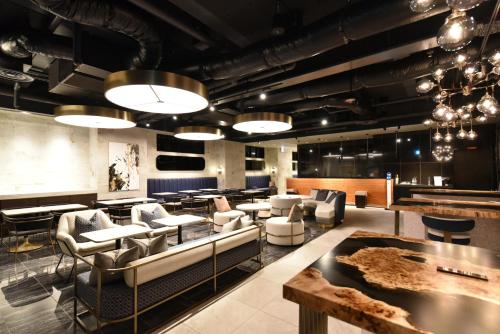 a lobby with couches and tables and a bar at Hotel Cordia Osaka Hommachi in Osaka
