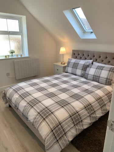 a bedroom with a bed and a window at Peartree Lodge in Cambourne