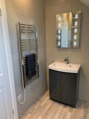 a bathroom with a sink and a mirror at Peartree Lodge in Cambourne