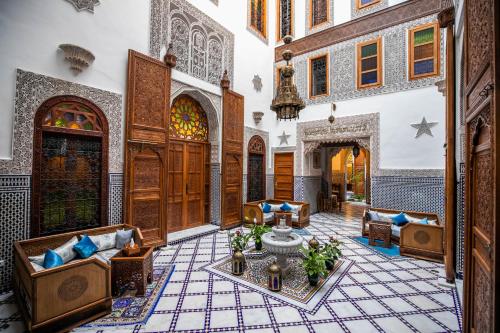 a living room with a table in a building at Riad Sidrat Fes in Fès