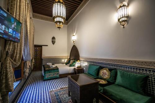 a living room with a green couch and a bed at Riad Sidrat Fes in Fès