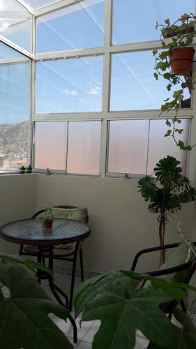 a room with a table in front of a window at Arcopata Apartamentos in Cusco