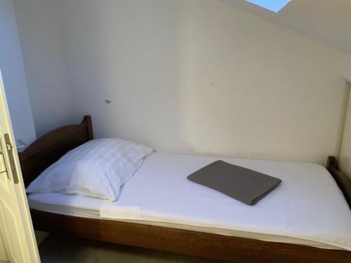 a bed in a small room with a book on it at Apartman Lili in Zaton