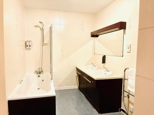 a bathroom with two sinks and a tub and a shower at The Lovat Hotel in Perth