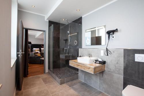 La salle de bains est pourvue d'un lavabo et d'une douche. dans l'établissement Elens Hotel, à Brême