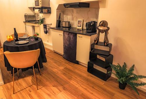 a dining room with a table and a kitchen at La loveroom bdsm grassoise "La chambre des désirs" in Grasse