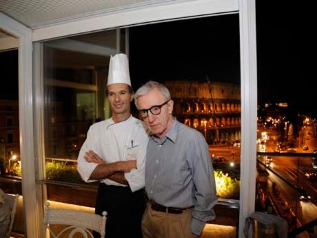 Due uomini con cappelli da chef in piedi su un balcone di Bes Colosseo Suites a Roma
