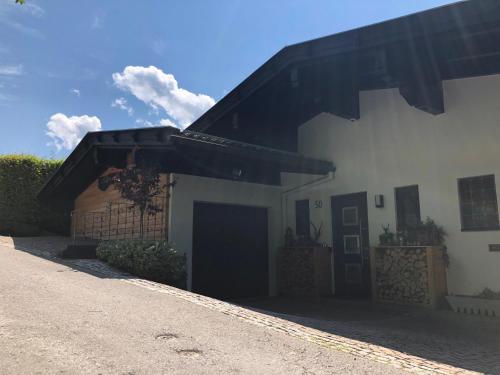 a white house with a black roof and a driveway at Landhaus Osttirol in Iselsberg