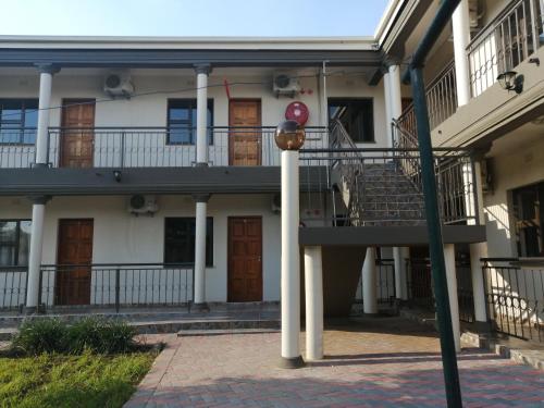 a building with a staircase and a balcony at LALA POA GUEST HOUSE in Klerksdorp