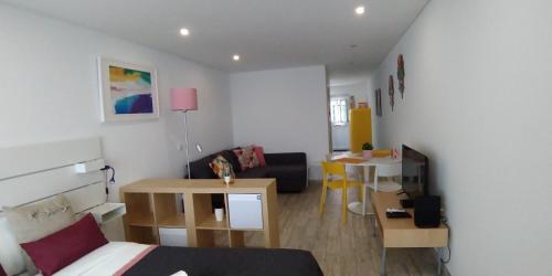 a room with a bed and a table and a couch at Tomarhousing - Old Town in Tomar