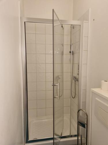 a shower with a glass door in a bathroom at Hotel Café de la Gare in Sainte-Foy-la-Grande
