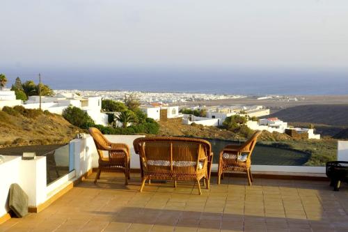 a group of chairs sitting on a patio with a view at Villa Feliza in Güime
