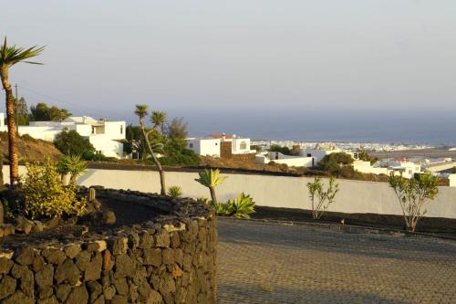 a street with houses and palm trees and a wall at Villa Feliza in Güime