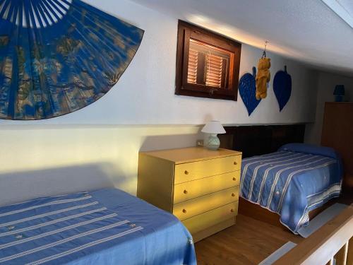 圣特奥多罗villino D5 coda cavallo villaggio cala paradiso的一间卧室配有两张床、一个梳妆台和一张床。