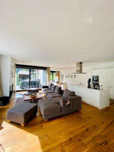 a large living room with a couch and a kitchen at Schooren des Alpes Luxury Penthouses & Apartments with SPA & Pools close Ischgl in Kappl