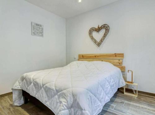 um quarto com uma cama com um sinal de coração na parede em Ceriflor-Le Vignemale em Cauterets