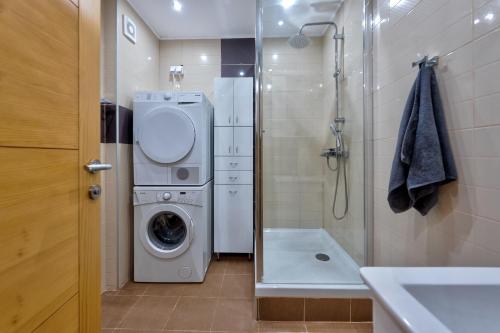 a bathroom with a washing machine and a shower at Apartman LUNI in Zlatibor