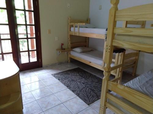 a room with two bunk beds in a room at Casa 5 suítes com piscina e churrasqueira in Ubatuba