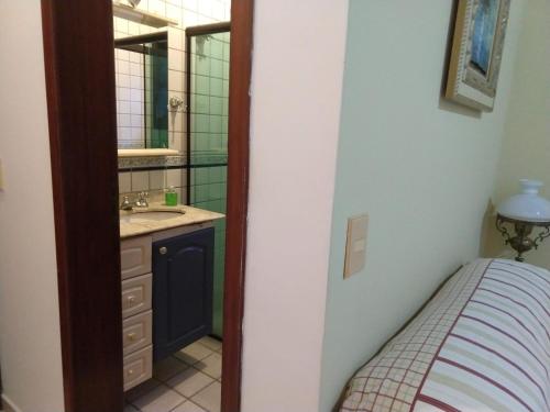 a small bathroom with a sink and a mirror at Casa 5 suítes com piscina e churrasqueira in Ubatuba