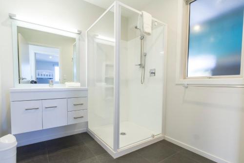 a white bathroom with a shower and a sink at Blae Loch - Lake Tekapo in Lake Tekapo