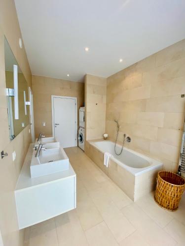 a large bathroom with two sinks and a tub at Schooren des Alpes Luxury Penthouses & Apartments with SPA & Pools close Ischgl in Kappl