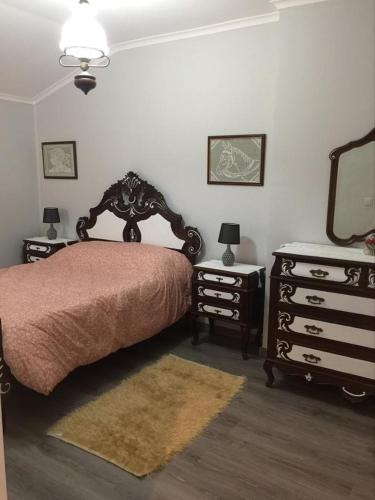 a bedroom with a bed and a dresser and a mirror at Casa das Bonecas in Mangualde