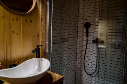 a bathroom with a white sink and a shower at Siedlisko pod Krukiem - Jurta in Suwałki