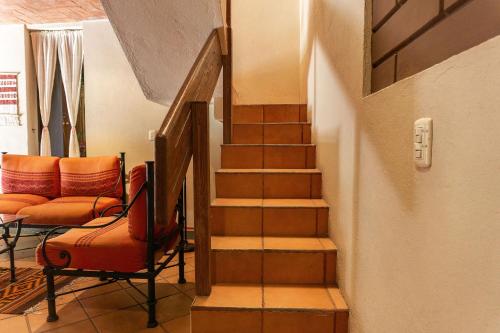 a staircase in a living room with a chair and a couch at Hotel Casa Pereyra in Oaxaca City