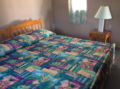 a bed with a colorful quilt on it in a bedroom at Rest Haven Beach Cottages in Saint Joseph