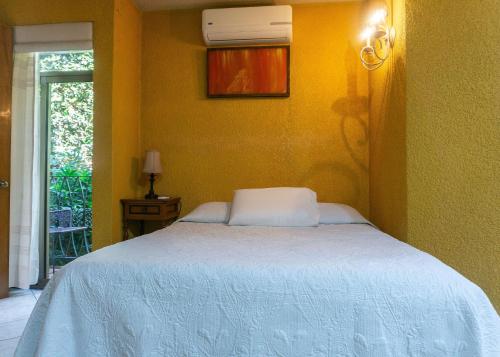 a bedroom with a bed with a white bedspread at Hotel Casa Pereyra in Oaxaca City
