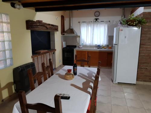 cocina con mesa blanca y nevera blanca en Quinta El Descanso en Puerto Madryn
