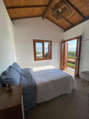 a bedroom with a bed and a table and a window at Pousada Refúgio Náutico in Passo de Torres