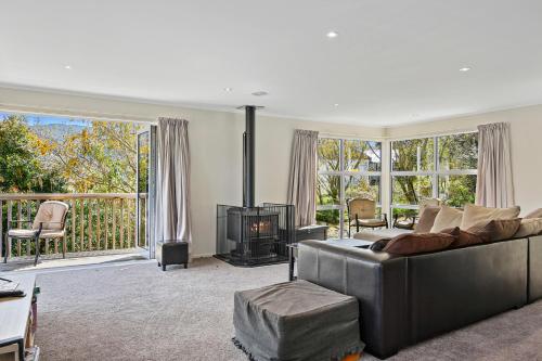a living room with a couch and a fireplace at Millard House - Marlborough Sounds in Grove
