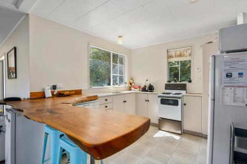 a kitchen with a wooden counter top and a refrigerator at Millard House - Marlborough Sounds in Grove