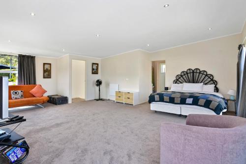 a bedroom with a bed and a couch at Millard House - Marlborough Sounds in Grove