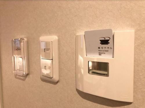 a white machine on a wall with two controllers at Henn na Hotel Premier Nara in Nara