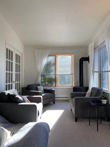 a living room with three couches and a fireplace at Chalet «L'Autrichien» de Charlevoix in Petite-Rivière-Saint-François